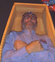 A mock burial of a modern man with his arms crossed reminiscent of ancient burials.
